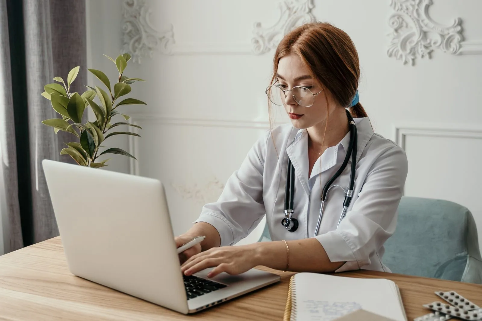 A physician reviewing practice information on a laptop