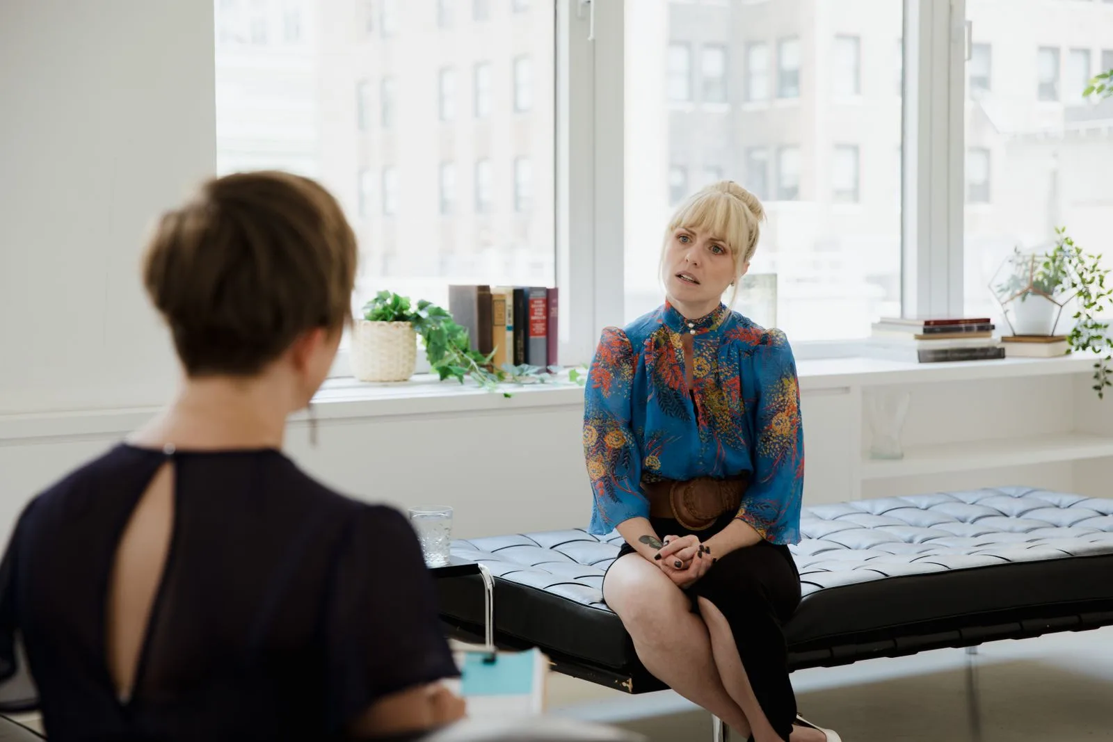 A therapist speaking with a patient in a bright office