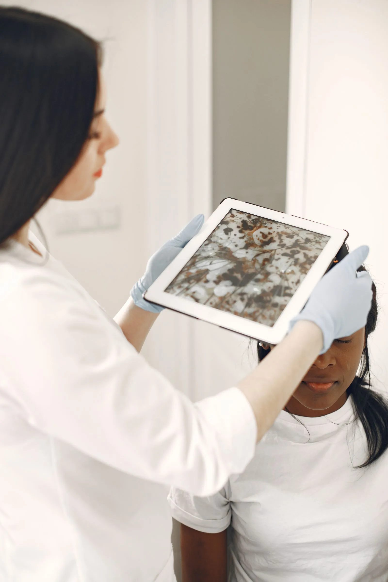A dermatologist using a digital tool during a skin examination